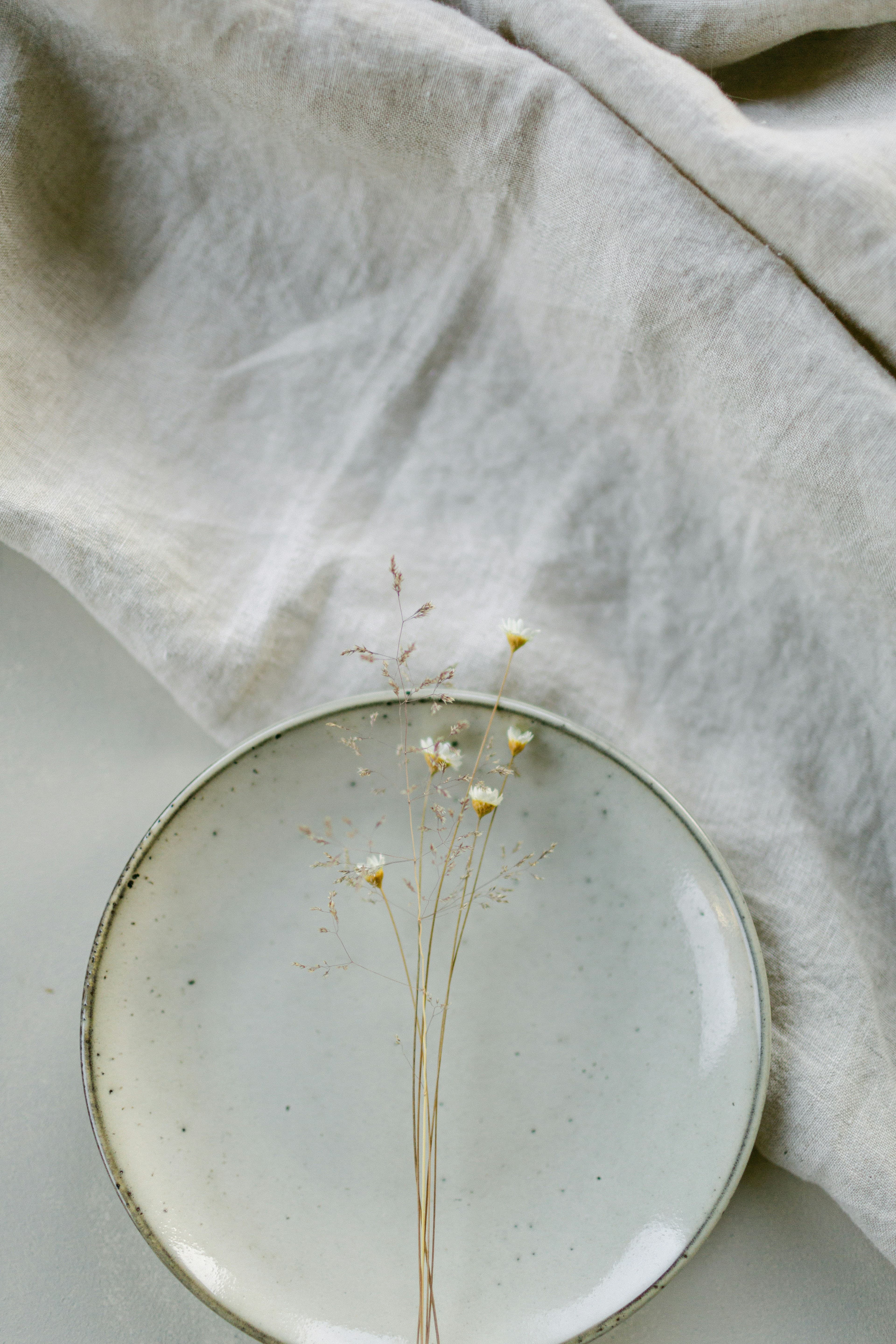 Ivory linen and a glass plate with dried flowers