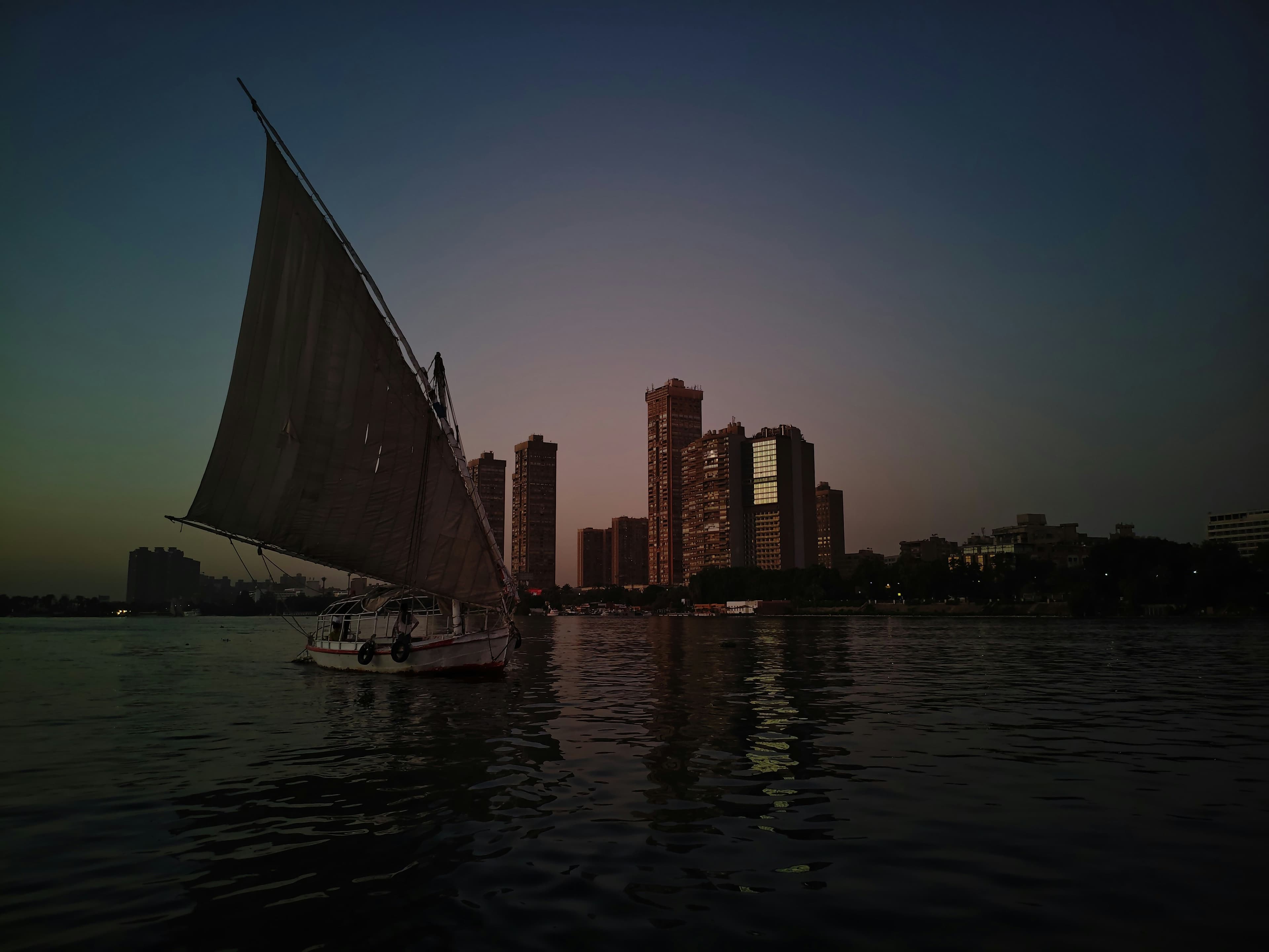 A felucca on the Nile with the Cairo skyline at dusk