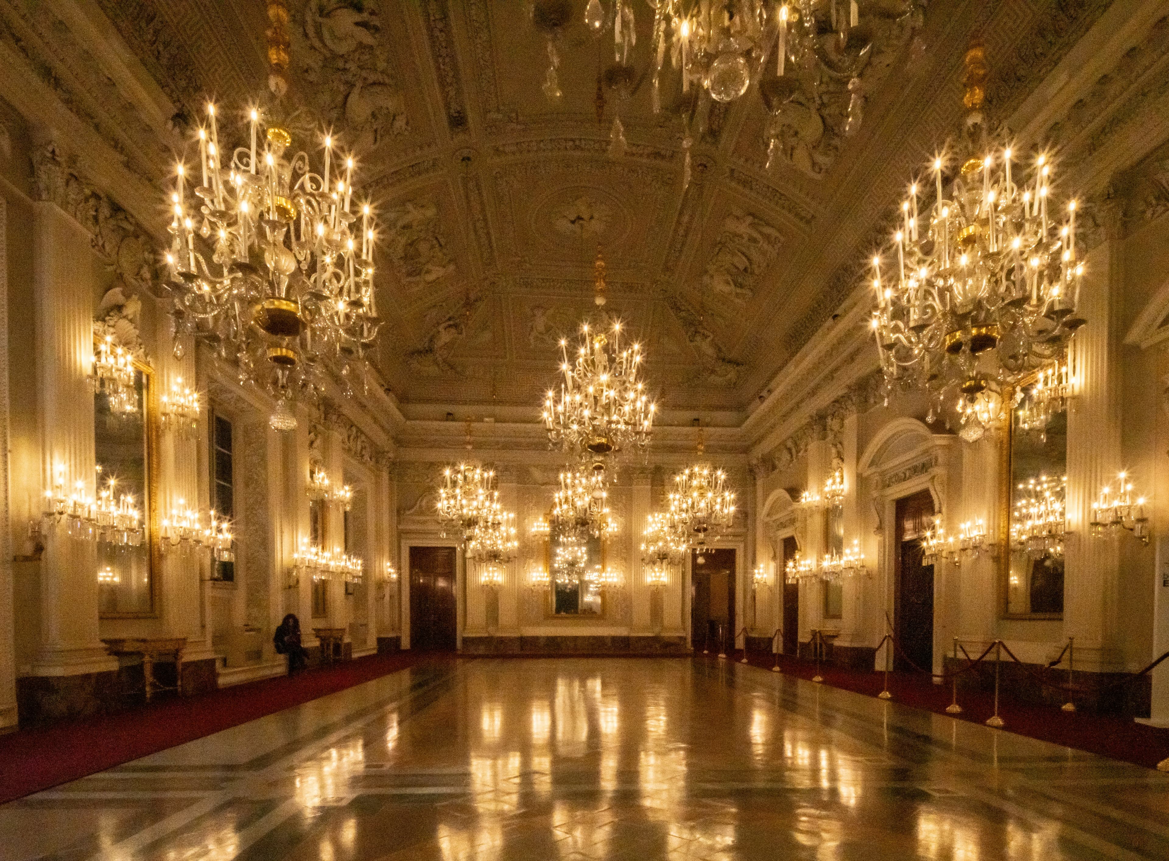 A grand ballroom with crystal chandeliers and a polished floor