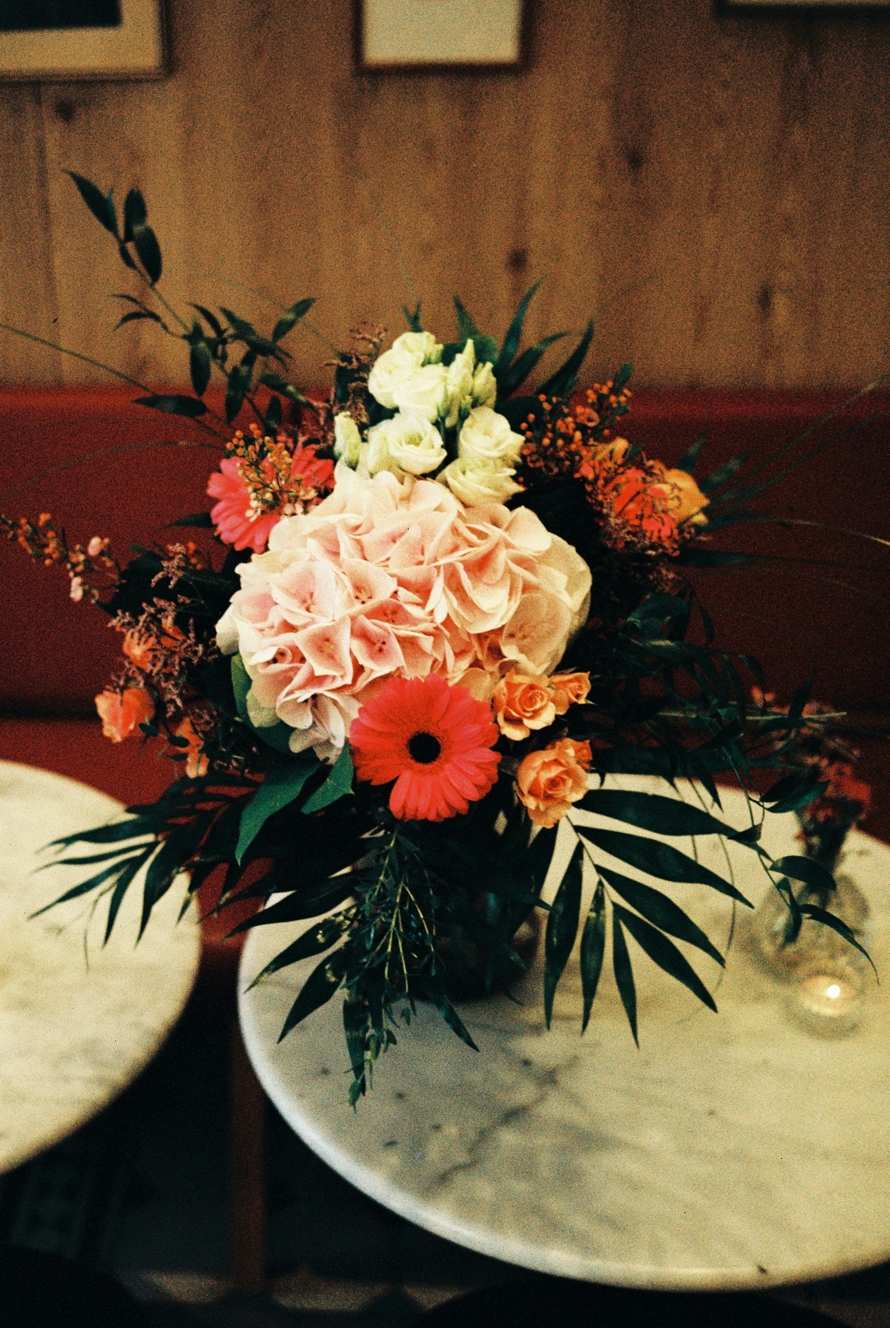 A floral centrepiece of hydrangeas and roses on marble