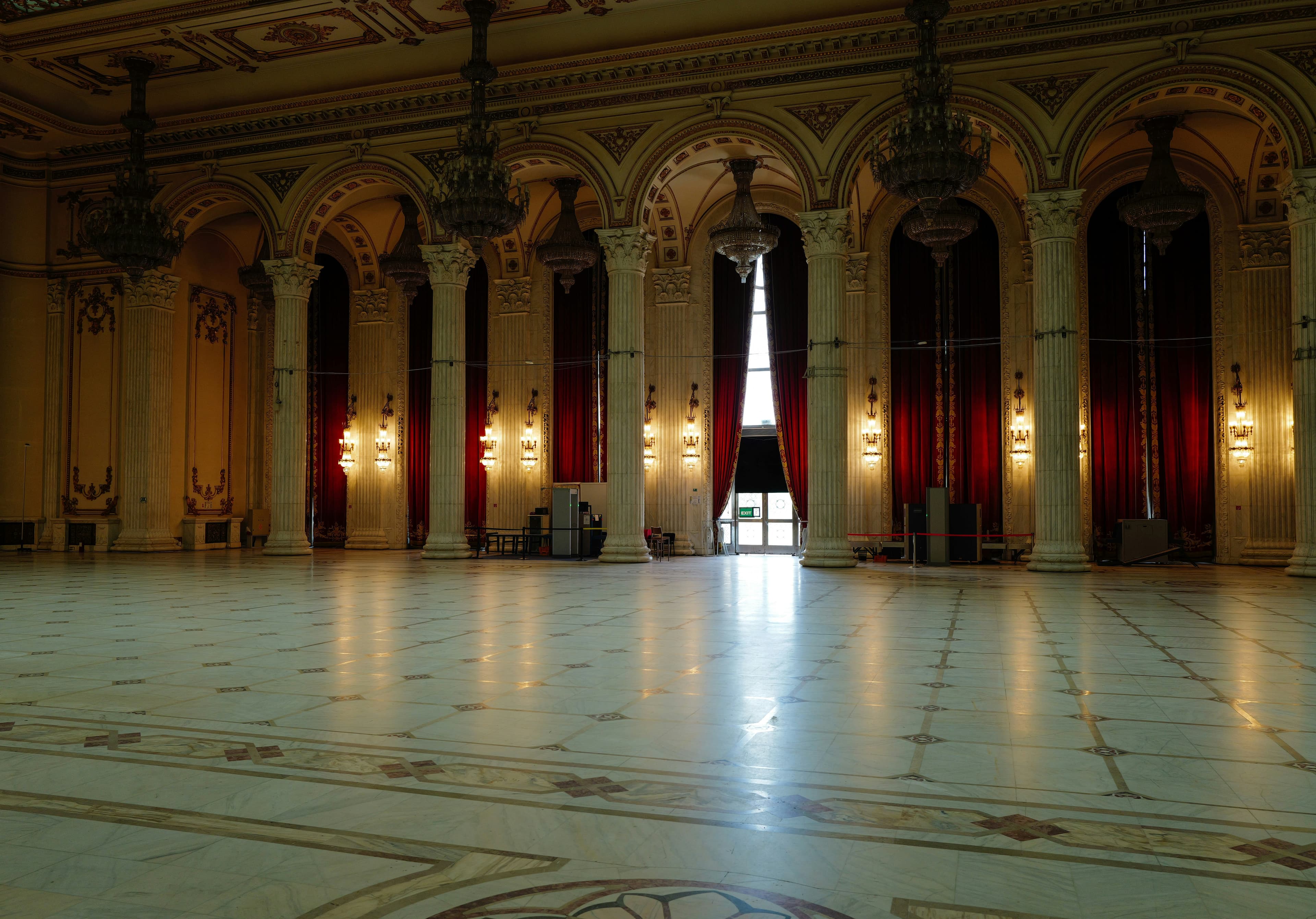 A ballroom with marble floors and tall columns